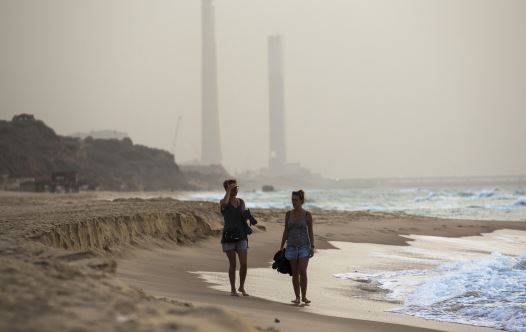 Tourists walk at the shore of the Mediterranean sea in Ashkelon in southern Israel during heavy hazy weather in the region (credit: REUTERS)