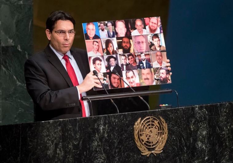 Israel's ambassador to the UN, Danny Danon, holds up a collage of terrorism victims