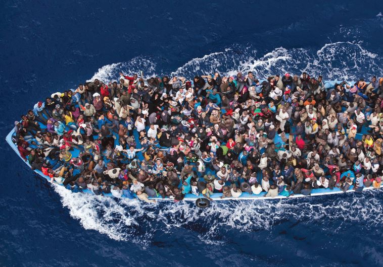 Massimo Sestini’s entry, which took second place in the General News slot, is a colorful overhead shot of refugees packed into a boat off the Libyan coast, prior to being rescued by an Italian naval frigate. (credit: MASSIMO SESTINI)