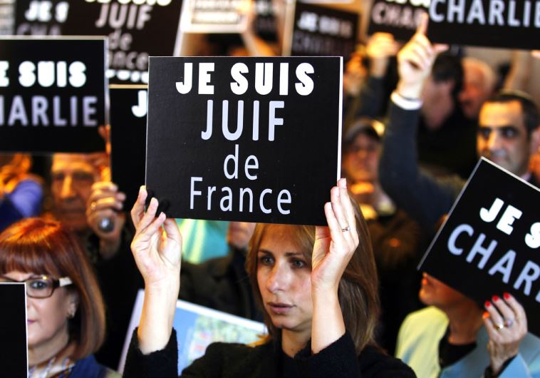 People hold up signs at a rally in Jerusalem, January 11, following terror attacks in France (credit: REUTERS)
