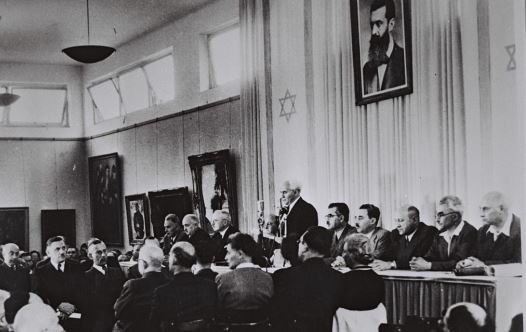 David Ben-Gurion, flanked by the members of his provisional government, reads the Declaration of Independence in the Tel Aviv Museum Hall (credit: GPO)