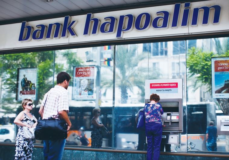 A WOMAN uses an automated teller machine outside a Bank Hapoalim branch in Tel Aviv three years ago.