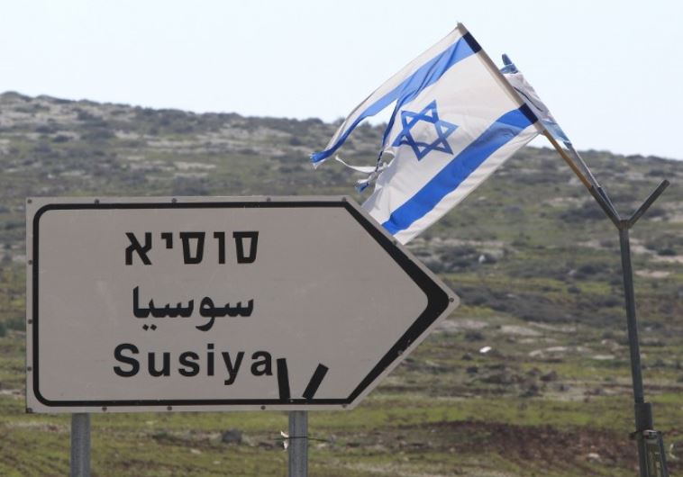 A road sign in English, Hebrew, and Arabic points to the Israeli settlement of Susiya (credit: AFP PHOTO)