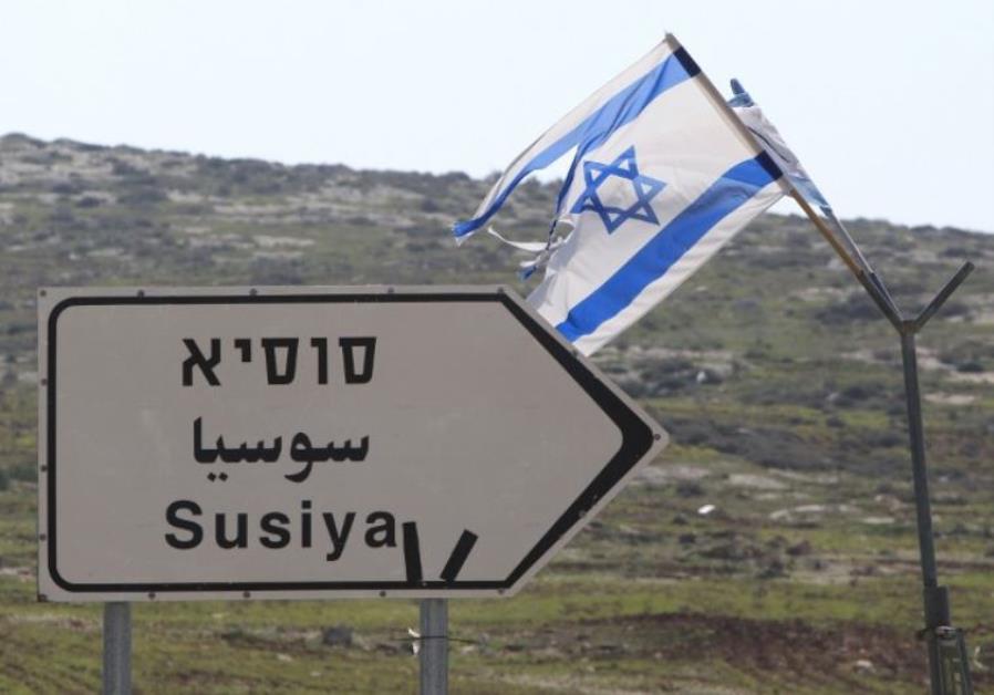 A road sign in English, Hebrew, and Arabic points to the Israeli settlement of Susiya