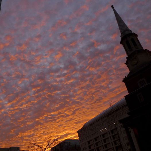 Early morning clouds are reflected in a window at sunrise across the New York Avenue Presbyterian Church steeple in Washington January 6, 2012.