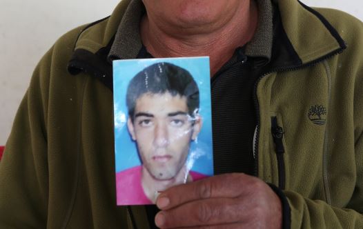 Sha'aban al-Sayed, father of Hisham, a Beduin Israeli who disappeared a year beforehand from his home in the Negev desert, shows a photo of his son at their family home in Hura on April 13, 2016