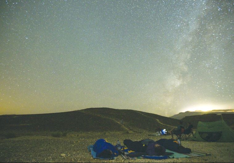 PEOPLE SLEEP through the annual Perseid meteor shower in the Ramon Crater last August. (credit: REUTERS)