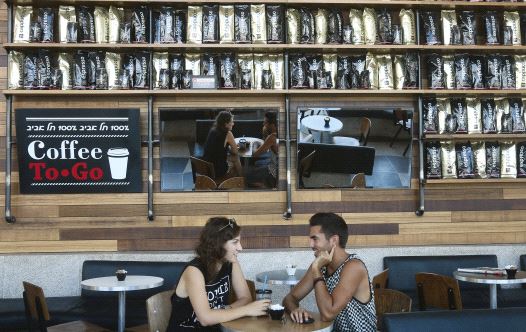 A couple relax at a branch of Aroma in Tel Aviv, one of Israel’s most successful coffee chains (credit: MARC ISRAEL SELLEM)