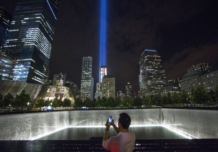 A man takes a photo at the 9/11 Memorial and Museum near the Tribute in Light in Lower Manhattan, New York