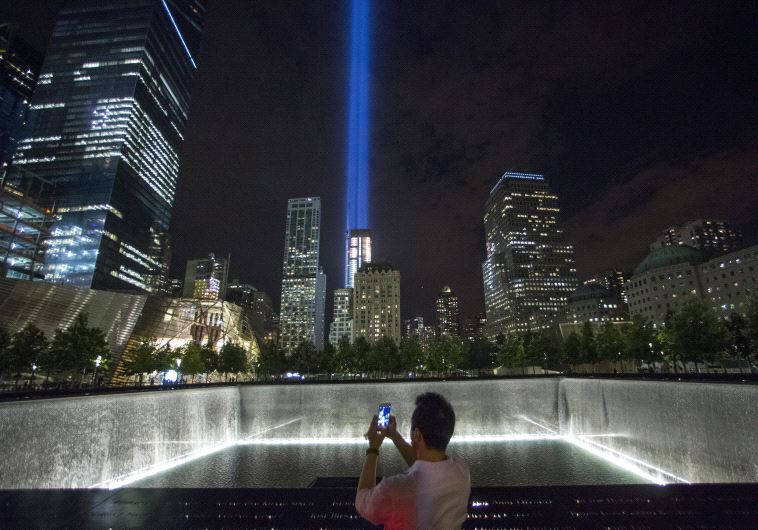 A man takes a photo at the 9/11 Memorial and Museum near the Tribute in Light in Lower Manhattan, New York (credit: REUTERS)