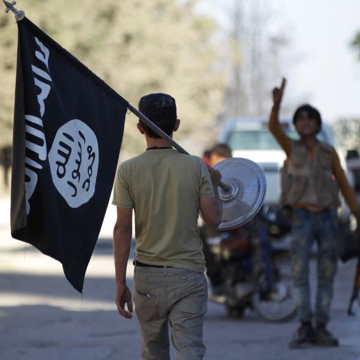 A rebel fighter takes away a flag that belonged to Islamic State militants in Akhtarin village, after rebel fighters advanced in the area, in northern Aleppo Governorate, Syria, October 7, 2016 (credit: REUTERS)