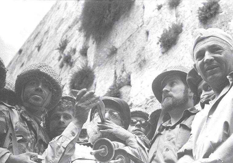 IDF CHIEF RABBI Shlomo Goren blows a shofar while he clutches a Torah scroll at the Western Wall on the day Jerusalem was reunified in June 1967