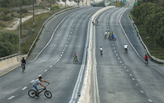 Children ride their bicycles in an empty street in Jerusalem during Yom Kippur (credit: MARC ISRAEL SELLEM)