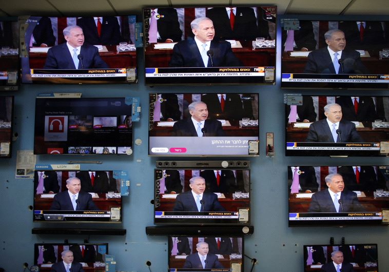Netanyahu is seen delivering his speech to the U.S. Congress on television screens in an electronics store in a Jerusalem shopping mall March 3, 2015 (credit: REUTERS)