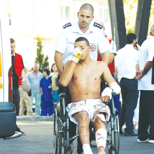 AN ISRAELI SURVIVOR of the Hezbollah bombing at Burgas, Bulgaria, on July 19, 2012, is wheeled to a waiting ambulance as he leaves the hospital. (credit: REUTERS)