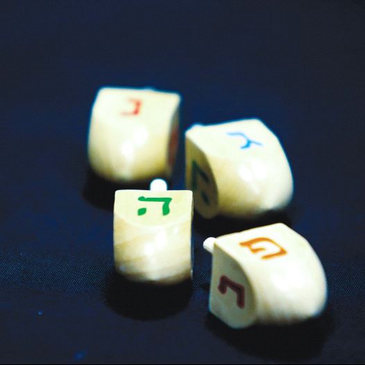 HANUKKA DREIDELS display the letters of the Hebrew acronym for ‘A great miracle happened here.’ (credit: MARC ISRAEL SELLEM/THE JERUSALEM POST)