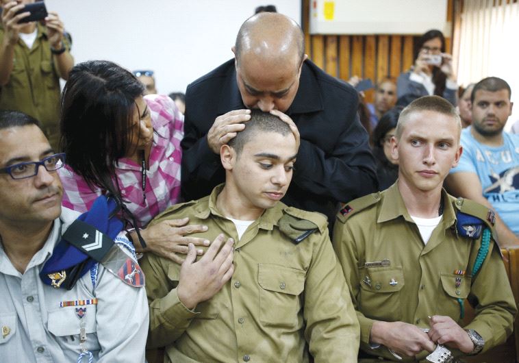 THE FATHER OF IDF soldier Elor Azaria kisses his head during a remand hearing last March (credit: REUTERS)