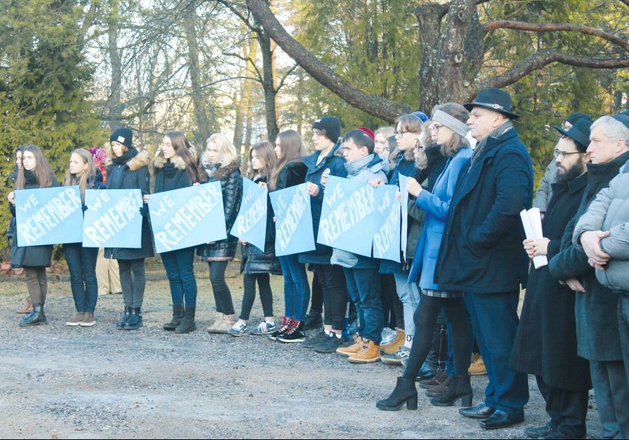 Jewish youth holding placards at the Tallinn cemetery. The rabbi of Estonia, Shmuel Kot, is second from the right (credit: BARRY DAVIS)