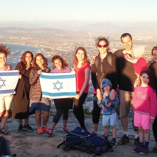 JEWISH AGENCY emissaries Aviad Sela (far right) and Hagai Dagan (holding the baby) pose for a photograph after a meeting of shlichim in Cape Town last year (credit: JAFI)