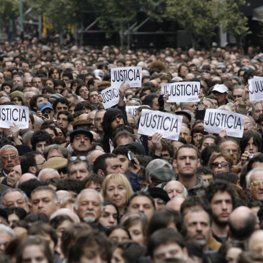 Hundreds of people, most of them members of the Argentine Jewish community, attend the commemoration of the 13th anniversary of the 1994 bombing of the AMIA Jewish community center in Buenos Aires July 18, 2007. The signs read, ''Justice. (credit: REUTERS)