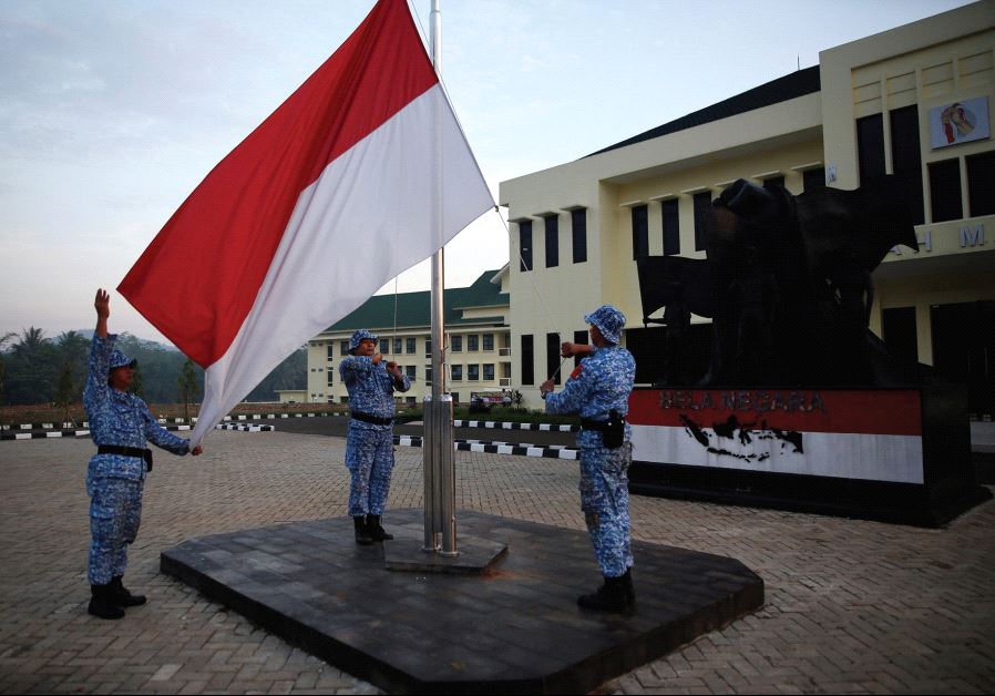 PARTICIPANTS RAISE an Indonesian flag at a training center in Rumpin, Indonesia, last June. (credit: REUTERS)