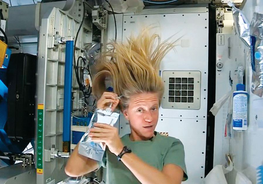 Nasa astronaut Karen Nyberg demonstrates how she washes her hair in zero gravity in outer space during a mission in 2013 (credit: NASA,REUTERS)
