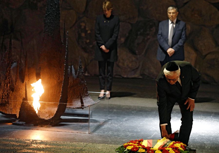 German President Frank-Walter Steinmeier touches a wreath during a ceremony commemorating the six mi