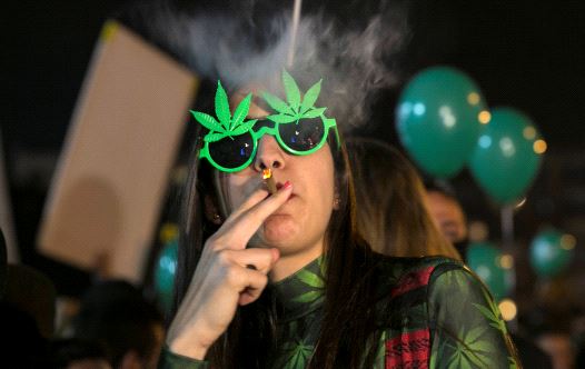 A woman smokes during an event marking Israel's government's approval of a new policy to decriminalize personal marijuana use in Tel Aviv, Israel February 4, 2017 (credit: REUTERS/BAZ RATNER)