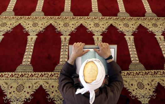 A Palestinian man reads the Koran in al-Aqsa Mosque in Jerusalem's Old City during the holy month of Ramadan (credit: REUTERS/AMMAR AWAD)