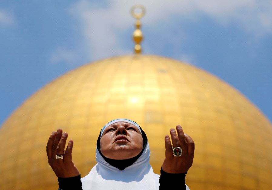 A Palestinian woman prays on the first Friday of the holy fasting month of Ramadan, at the Temple Mo