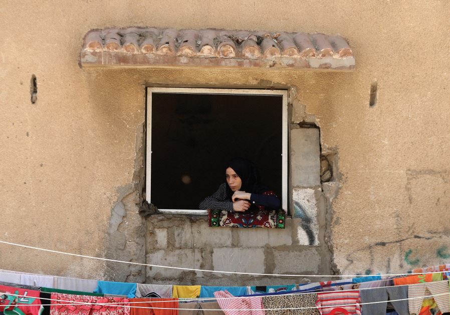 A WOMAN looks out a window in the Gaza Strip.