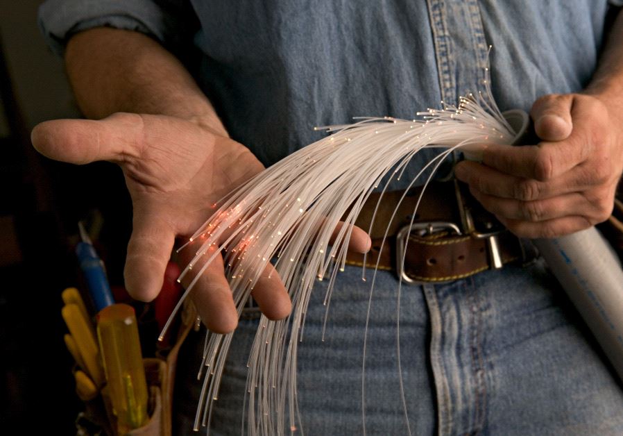 A worker holding a fiber optic cable