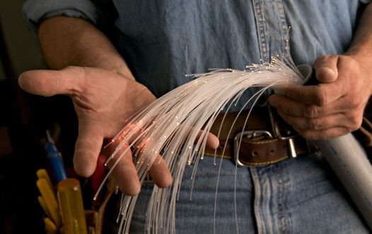 A worker holding a fiber optic cable