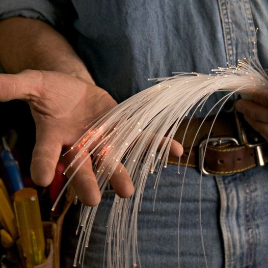 A worker holding a fiber optic cable