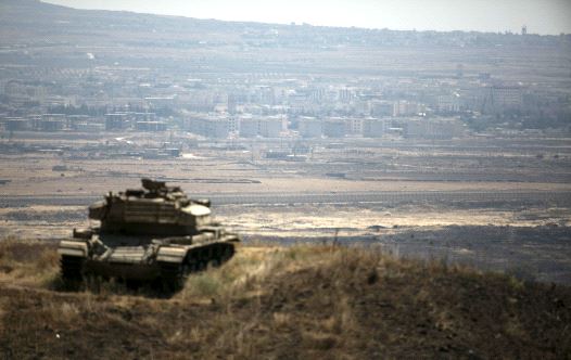 The Syrian area of Quneitra is seen in the background as an out-of-commission Israeli tank parks on a hill, near the ceasefire line between Israel and Syria, in the Golan Heights. (credit: BAZ RATNER/REUTERS)