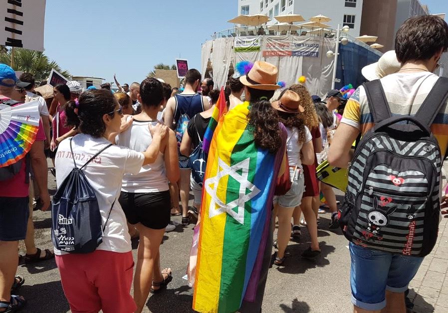 Participant with Jewish Pride flag walking in the 2017 Tel Aviv Pride Parade (credit: BECKY BROTHMAN)