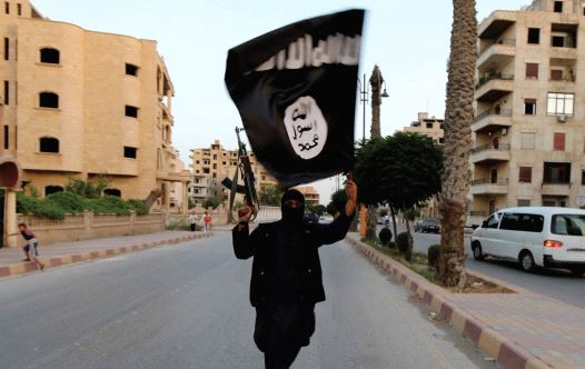 A MEMBER of ISIS waves the group’s flag in Raqqa (credit: REUTERS)