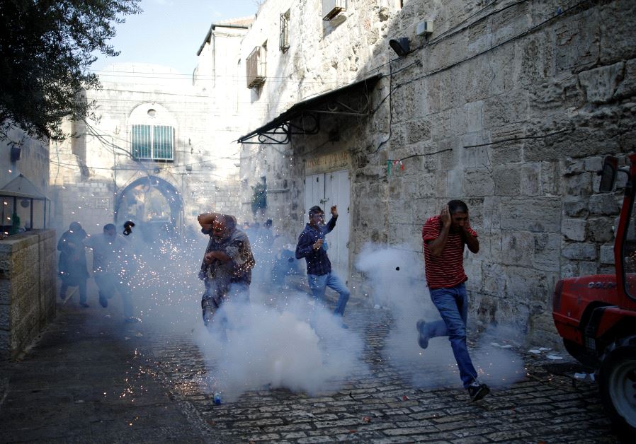 Palestinians react as a stun grenade explodes in a street at Jerusalem's Old city outside the Temple Mount, after Israel removed all security measures it had installed at the compound July 27, 2017. (Reuters)