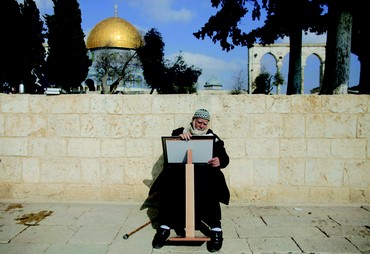 Un palestinien lit un Coran devant le Dome du Rocher