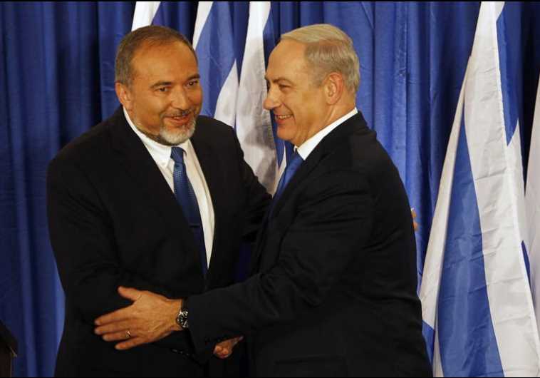 Prime Minister Benjamin Netanyahu (R) shakes hands with Foreign Minister Avigdor Liberman
