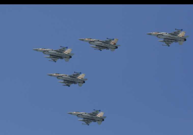 Israeli Air Force F-16 planes fly in formation over the Mediterranean Sea as seen from a Tel Aviv beach, April 23