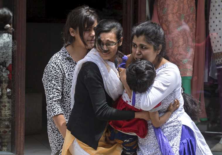 Local residents evacuate from a shop during an earthquake in central Kathmandu.