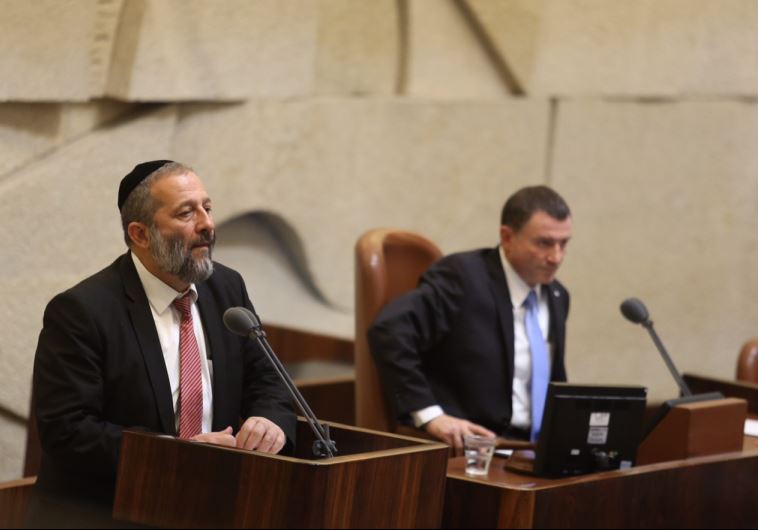 Economy Minister Aryeh Deri (L) speaks to the Knesset as speaker Yuli Edelstein looks on
