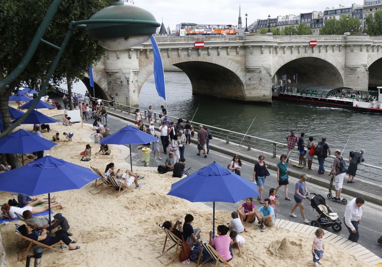 People relax as "Paris Plages" (Paris Beach) opens along the banks of River Seine in Paris, France, July 20, 2015.