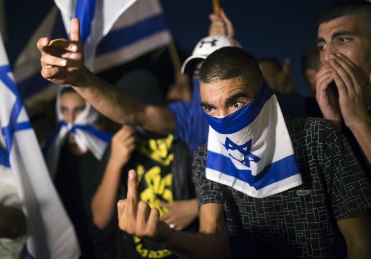 A right-wing Israeli activist gestures during a counter-protest against supporters of hunger-striking Palestinian detainee Mohammed Allan