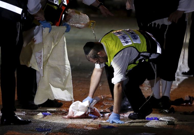 A member of the Zaka Rescue and Recovery team cleans blood stains at the scene where a Palestinian was shot dead after he stabbed and killed two people in Jerusalem's Old City