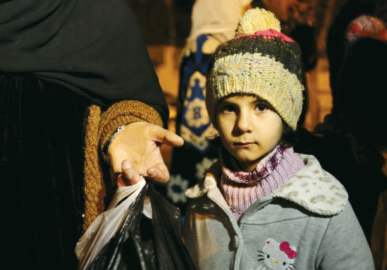 A SYRIAN girl waits with her family, who say they have received permission from the Syrian government to leave the besieged town, as they depart after an aid convoy entered Madaya, this week.