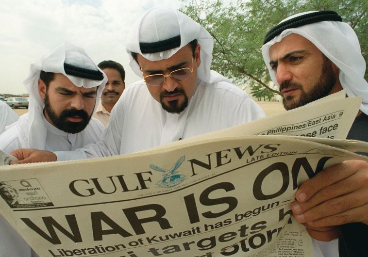 Kuwaiti exiles read a local newspaper announcing the start of the Gulf War in Dubai on January 17, 1991