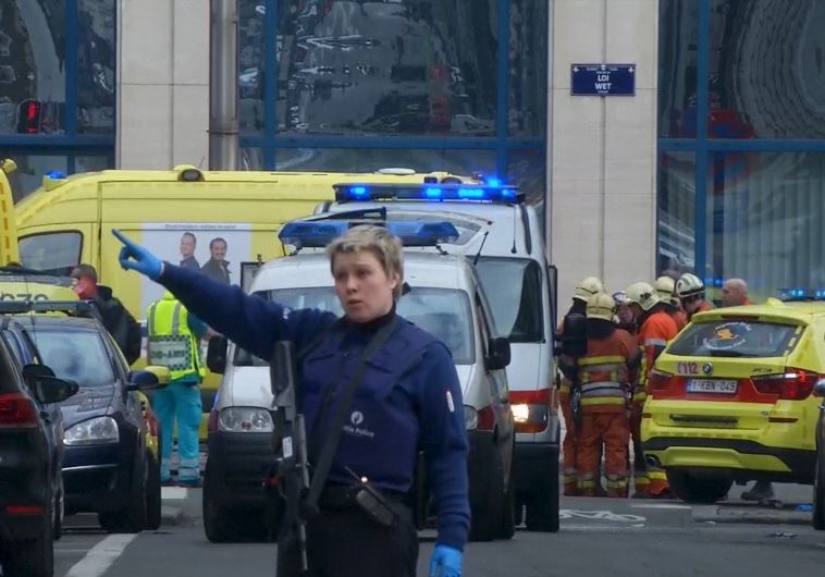 A police woman gestures in front of ambulances at the scene of a blast outside a metro station in Brussels, in this still image taken from video on March 22, 2016