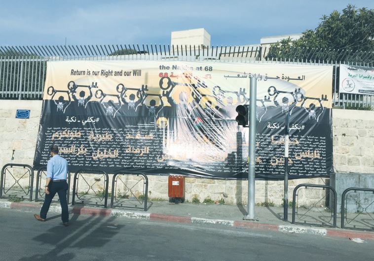 A MAN WALKS past posters calling for the right of return yesterday in Bethlehem